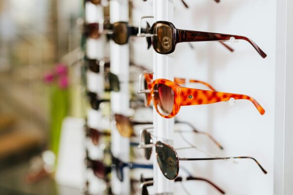 A vibrant assortment of fashionable sunglasses displayed on a store rack, ready for a trendy sale.