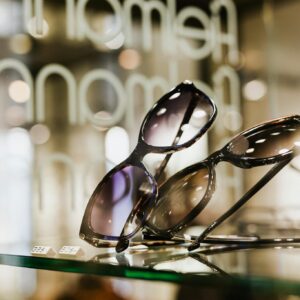 Elegant sunglasses showcased on a glass shelf in a stylish retail setting.