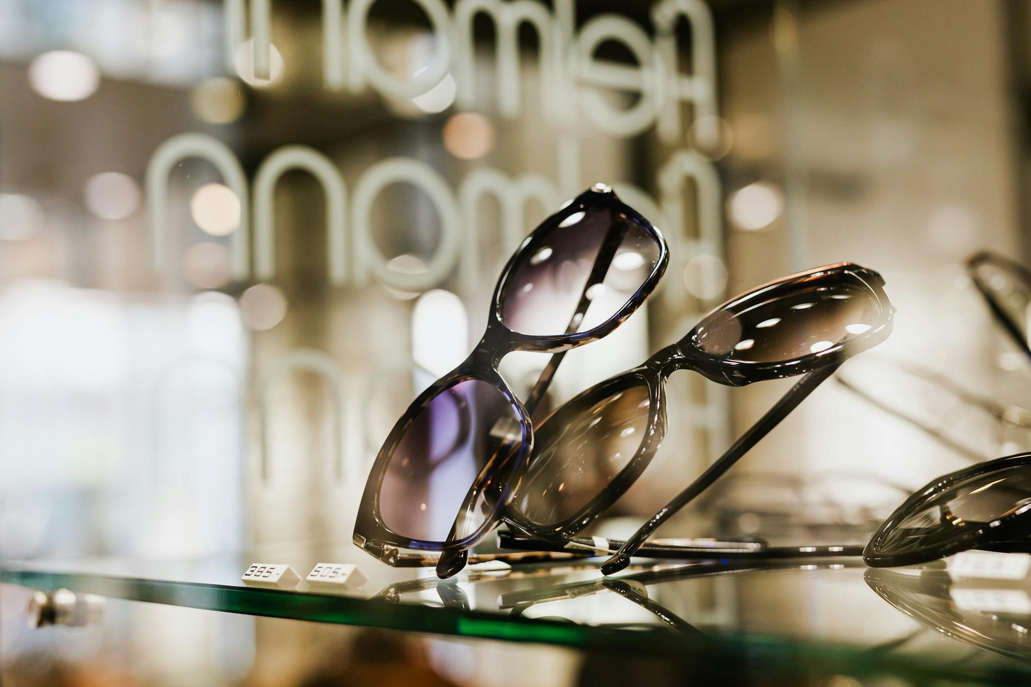 Elegant sunglasses showcased on a glass shelf in a stylish retail setting.