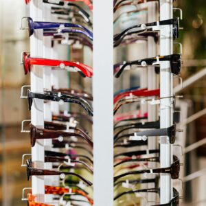 Vibrant array of eyeglasses on a display rack in a modern optical store.