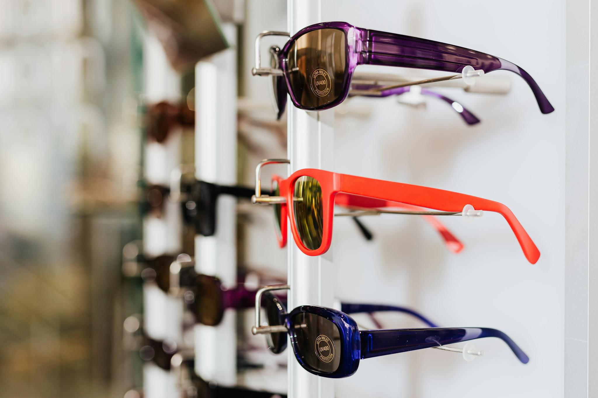 Vibrant sunglasses showcased on a white rack, perfect for fashion and eyewear themes.